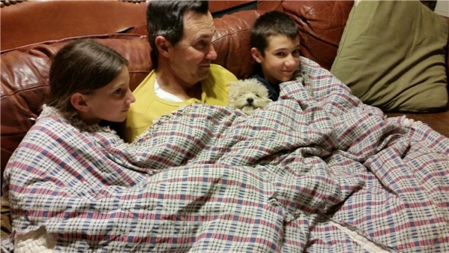 Nathan, the kids and Daisy cuddle on the couch